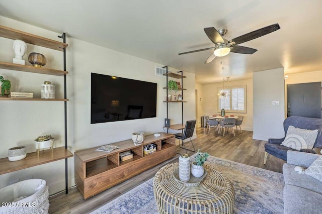 living room featuring ceiling fan, visible vents, and wood finished floors