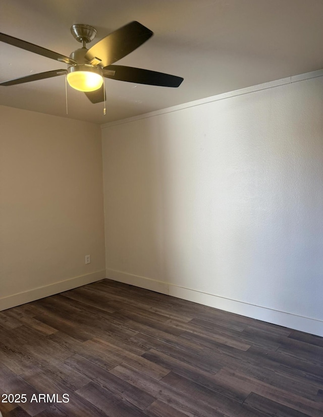 spare room featuring ceiling fan, crown molding, dark wood finished floors, and baseboards