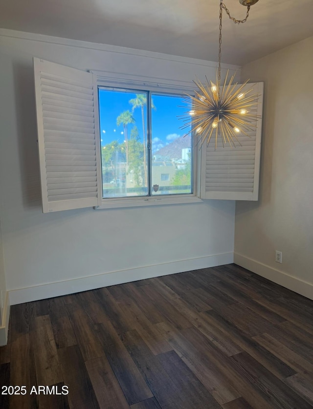 unfurnished room with baseboards, dark wood-type flooring, and a notable chandelier