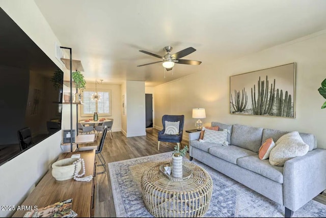 living room featuring ceiling fan, baseboards, and wood finished floors