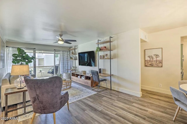 living room with ceiling fan, wood finished floors, and baseboards