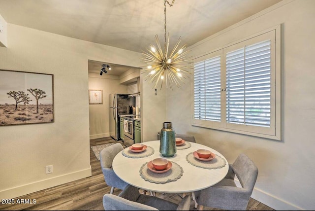 dining area with baseboards, a notable chandelier, and wood finished floors