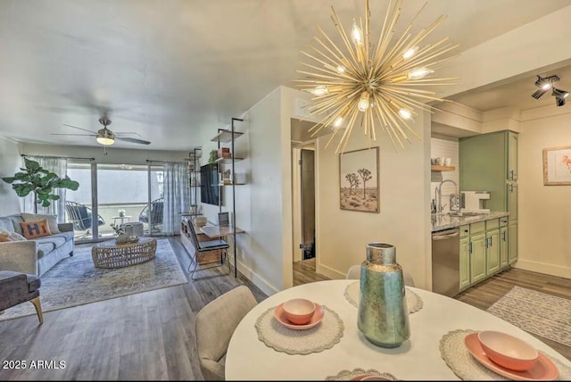 dining area with baseboards, wood finished floors, and ceiling fan with notable chandelier