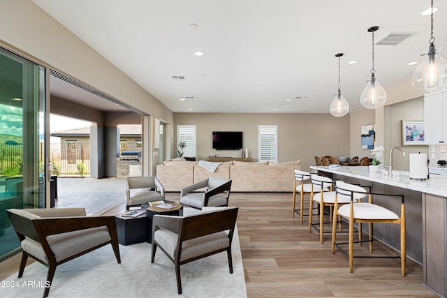 living area with light wood finished floors, plenty of natural light, visible vents, and recessed lighting