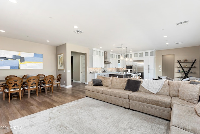 living area with wood finished floors, visible vents, and recessed lighting