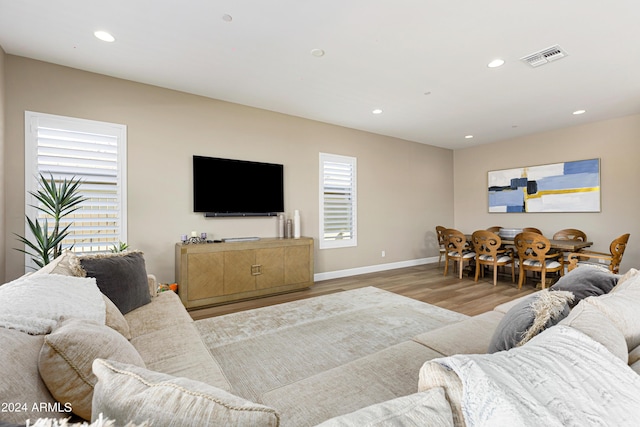 living room featuring a healthy amount of sunlight, light wood-type flooring, visible vents, and recessed lighting