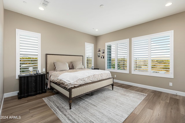 bedroom with baseboards, visible vents, wood finished floors, and recessed lighting