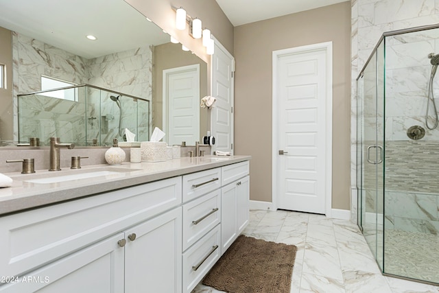 full bathroom with double vanity, a marble finish shower, baseboards, marble finish floor, and a sink