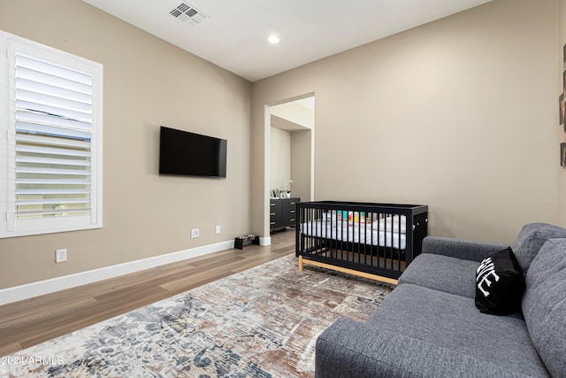 bedroom featuring recessed lighting, wood finished floors, visible vents, and baseboards