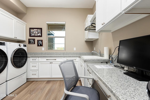 washroom featuring light wood finished floors, a sink, cabinet space, and washer and dryer