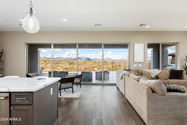 living room featuring dark wood-style floors, recessed lighting, visible vents, and a mountain view