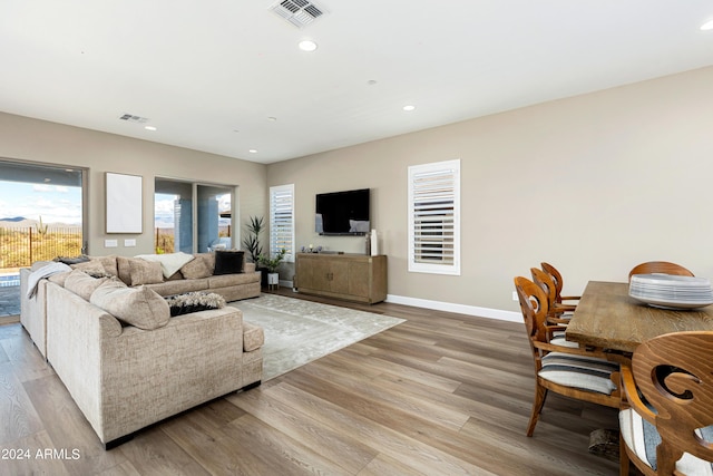 living room featuring light wood-style flooring, recessed lighting, visible vents, and baseboards