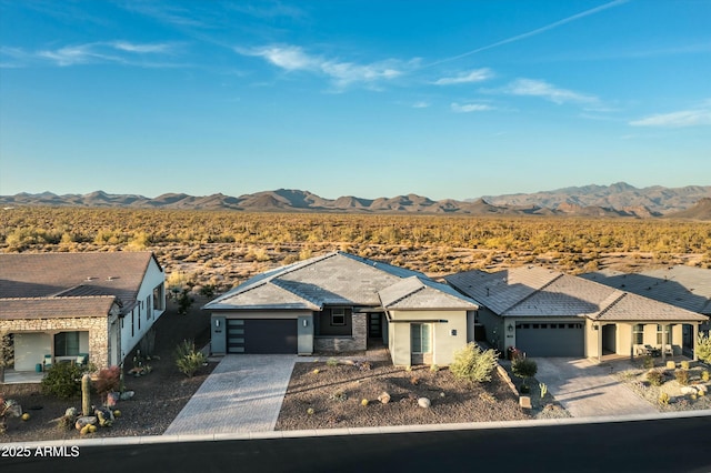 ranch-style home with an attached garage, a residential view, a mountain view, and decorative driveway