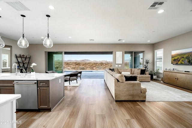 living room with a wealth of natural light, light wood finished floors, and visible vents