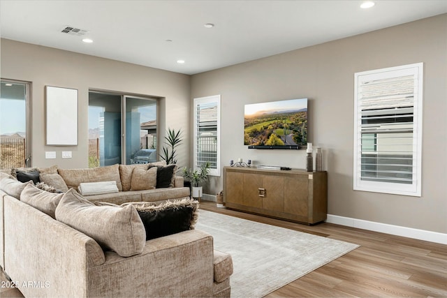 living area featuring light wood finished floors, recessed lighting, visible vents, and baseboards