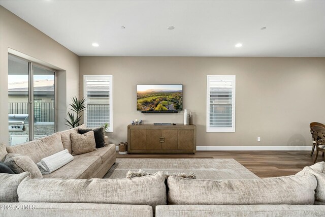 living room with baseboards, wood finished floors, and recessed lighting