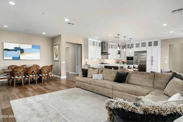 living room featuring visible vents, wood finished floors, and recessed lighting