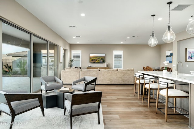 living area featuring light wood-style floors, recessed lighting, and visible vents