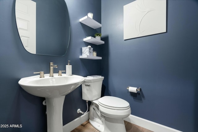 bathroom featuring baseboards, toilet, and wood finished floors