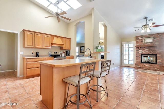 6102 W Shangri La Rd, Glendale, AZ 85304 - kitchen with ceiling fan, a sink, stainless steel range with electric stovetop, high vaulted ceiling, and custom range hood