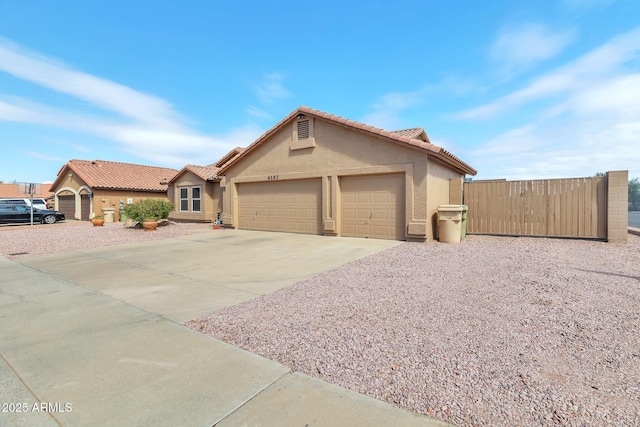 6102 W Shangri La Rd, Glendale, AZ 85304 - ranch-style home featuring a tile roof, fence, concrete driveway, an attached garage, and stucco siding