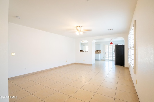 8055 W Sanna St, Peoria, AZ 85345 - spare room featuring a ceiling fan, arched walkways, light tile patterned floors, baseboards, and a smoke detector