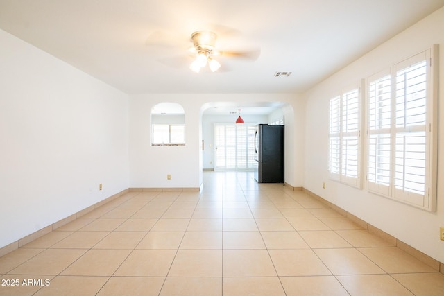 8055 W Sanna St, Peoria, AZ 85345 - unfurnished room with ceiling fan, arched walkways, light tile patterned floors, and baseboards