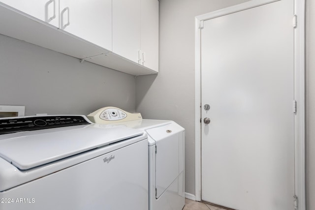 laundry area with separate washer and dryer and cabinets