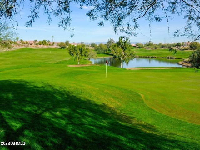 view of home's community featuring a water view and a lawn