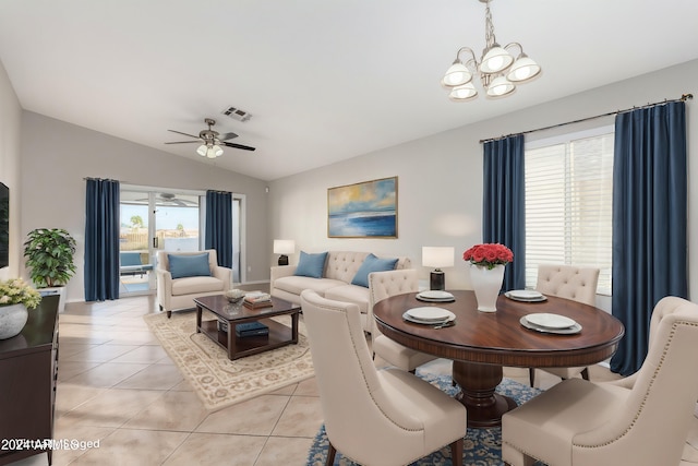 dining area featuring ceiling fan with notable chandelier, light tile patterned floors, and lofted ceiling