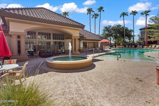 view of pool featuring pool water feature and a patio area