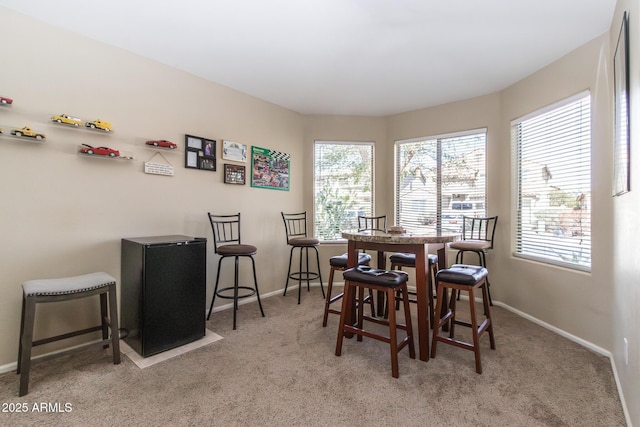 carpeted dining space with baseboards