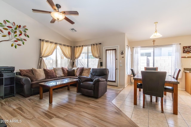 living area with vaulted ceiling, light tile patterned flooring, a ceiling fan, and visible vents