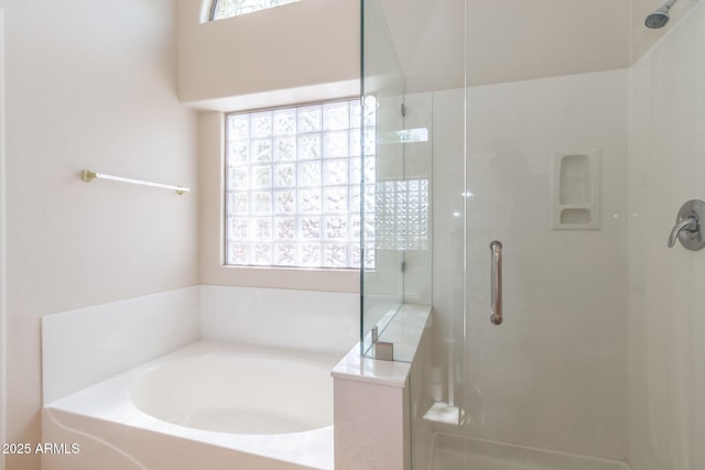 bathroom with a bath and a shower stall