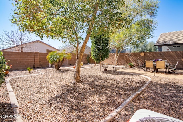 view of yard featuring outdoor dining space, central air condition unit, a patio area, and a fenced backyard