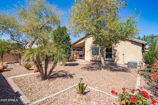 rear view of house featuring stucco siding, a fenced backyard, cooling unit, and a patio area