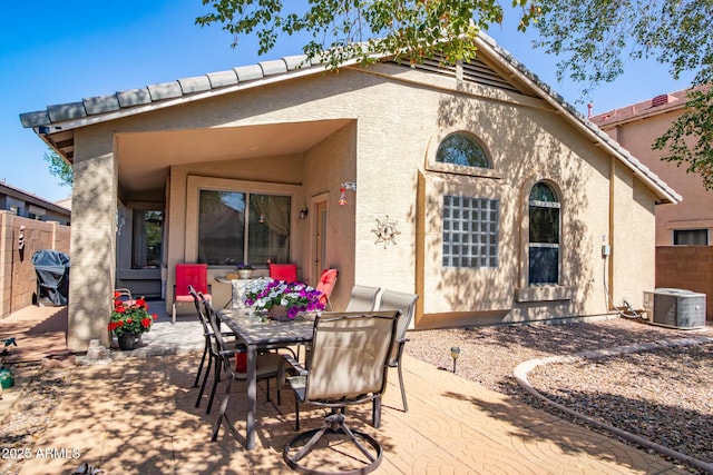 rear view of house with stucco siding, a patio, central air condition unit, and fence