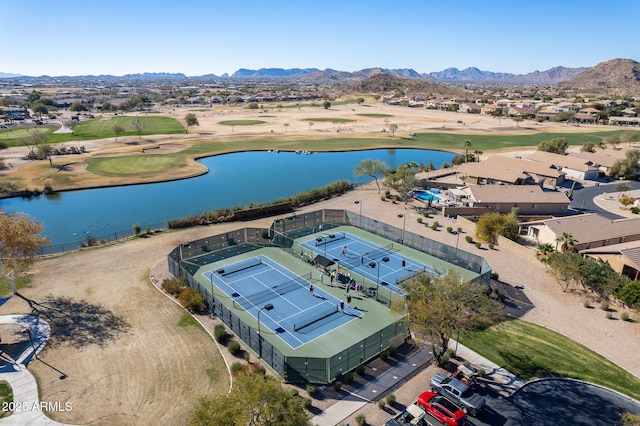 drone / aerial view with view of golf course and a water and mountain view