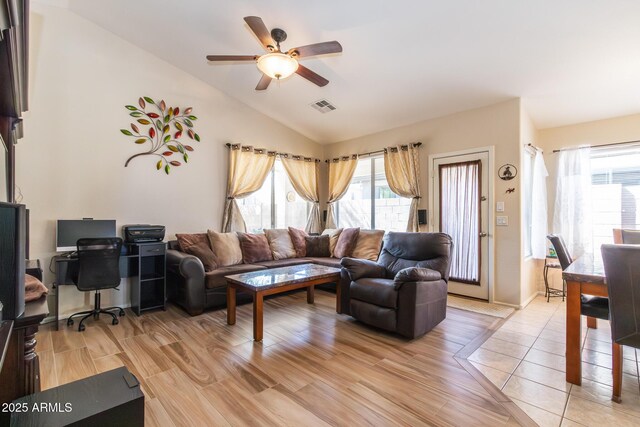 living room featuring visible vents, plenty of natural light, light wood-style flooring, and vaulted ceiling