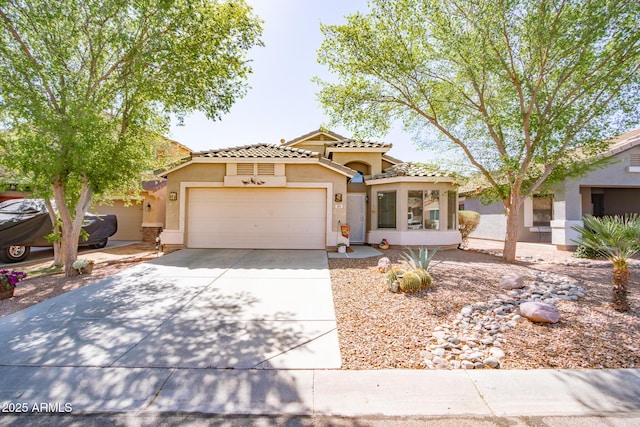 mediterranean / spanish-style house with a tile roof, an attached garage, driveway, and stucco siding