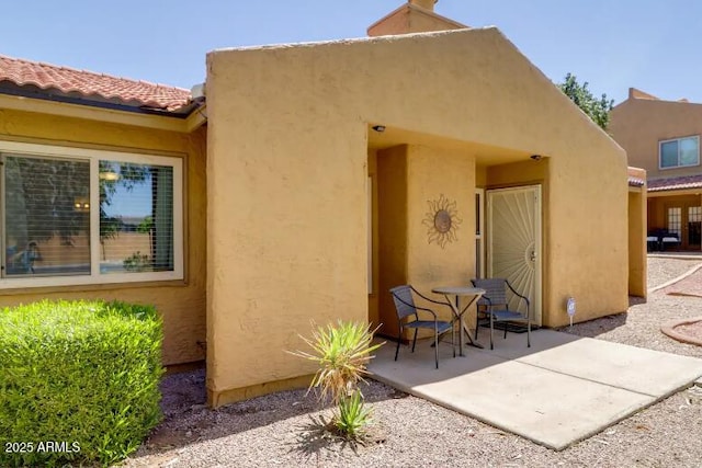 rear view of property featuring a patio and stucco siding