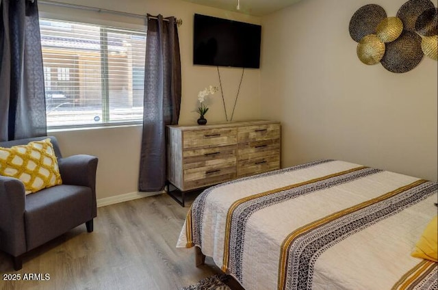 bedroom with baseboards and wood finished floors