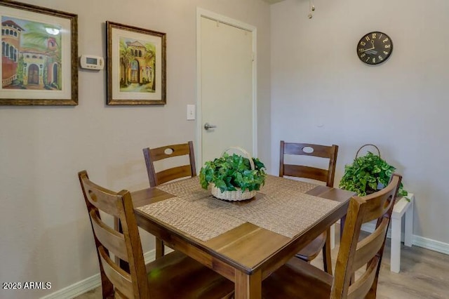 dining area featuring light wood-type flooring and baseboards