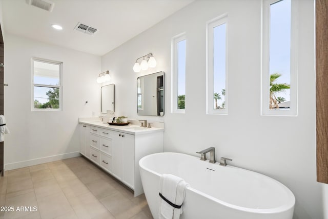 5537 E Earll Dr, Phoenix, AZ 85018 - bathroom featuring double vanity, a soaking tub, tile patterned flooring, baseboards, and recessed lighting