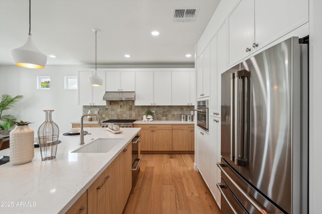 5537 E Earll Dr, Phoenix, AZ 85018 - kitchen with stainless steel appliances, a sink, light wood-style flooring, recessed lighting, and pendant lighting