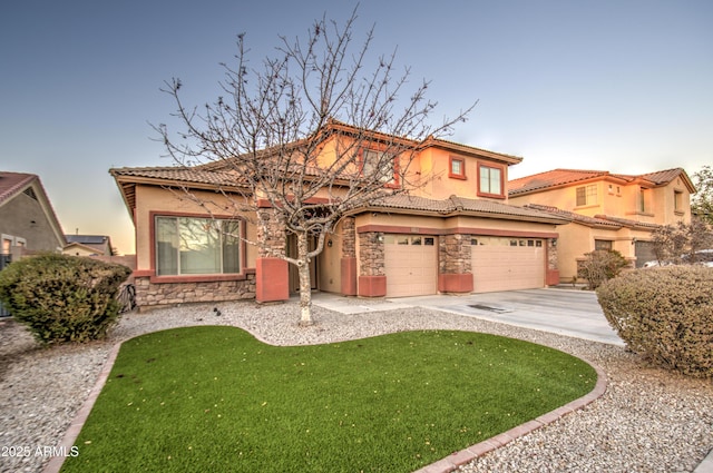 mediterranean / spanish-style home featuring a garage and a yard