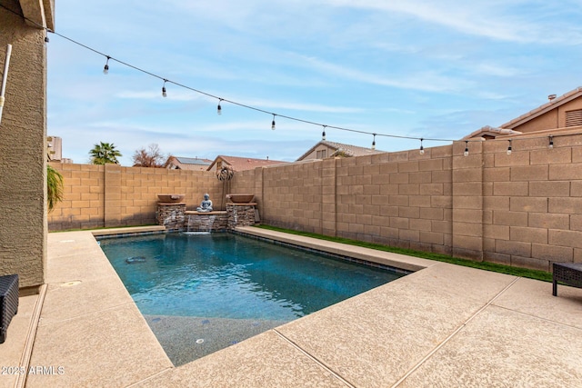 view of swimming pool with pool water feature and a patio area