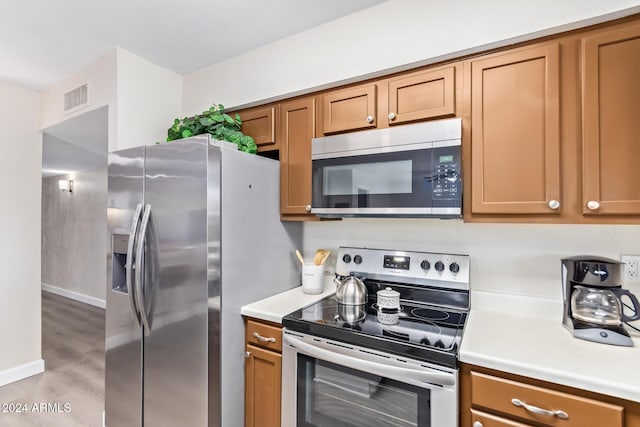 kitchen with light hardwood / wood-style flooring and appliances with stainless steel finishes