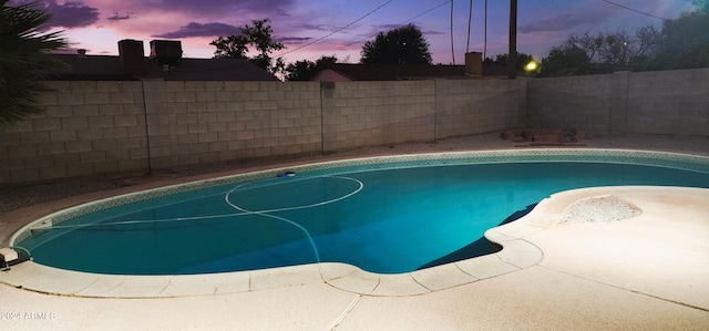 view of pool at dusk