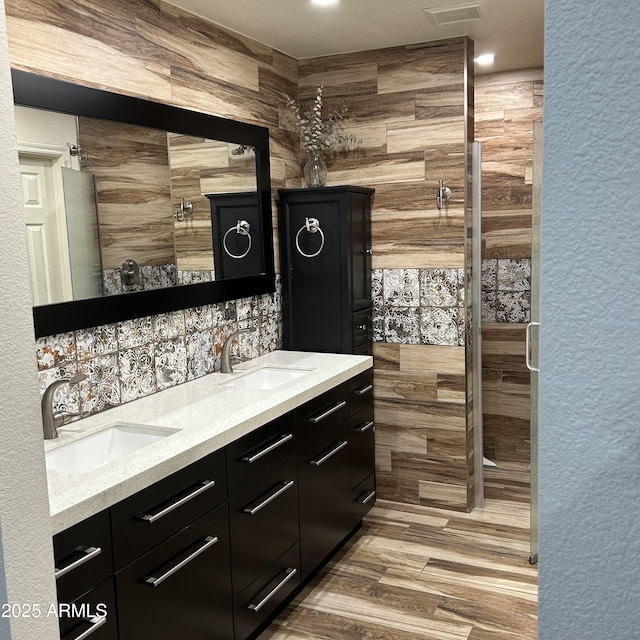 bar featuring light wood finished floors, indoor wet bar, and a sink